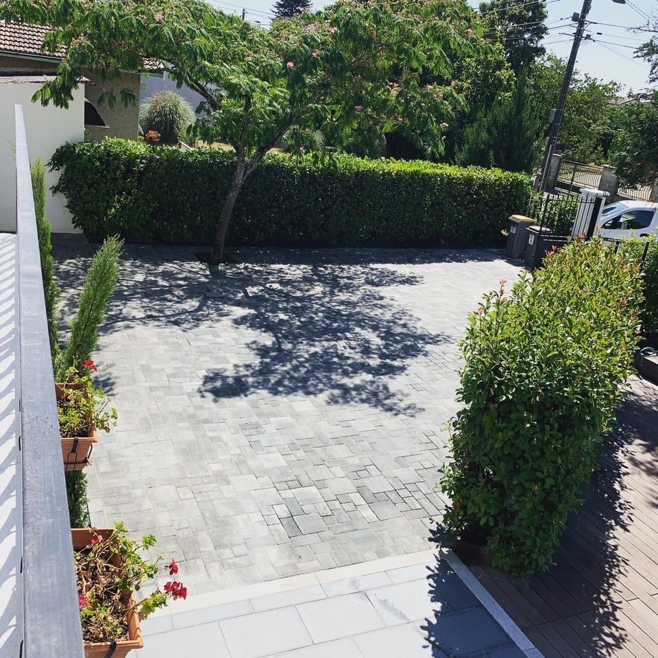 Allée en pierre entre une maison et son portail d'entrée