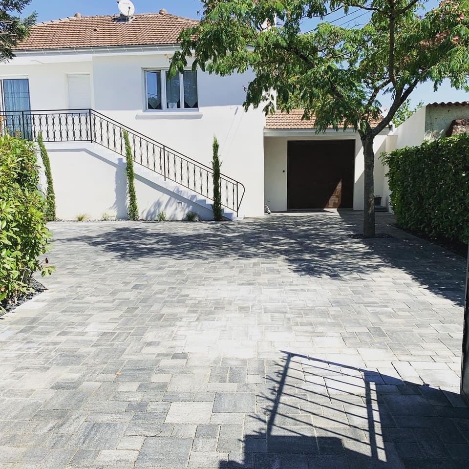 Allée en pierre menant vers une habitation et son garage