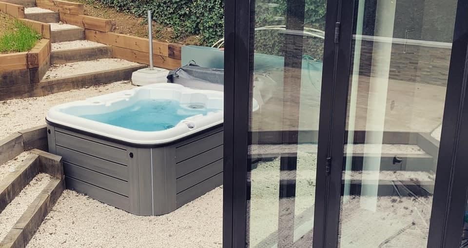 Petit spa extérieur posé sur des cailloux