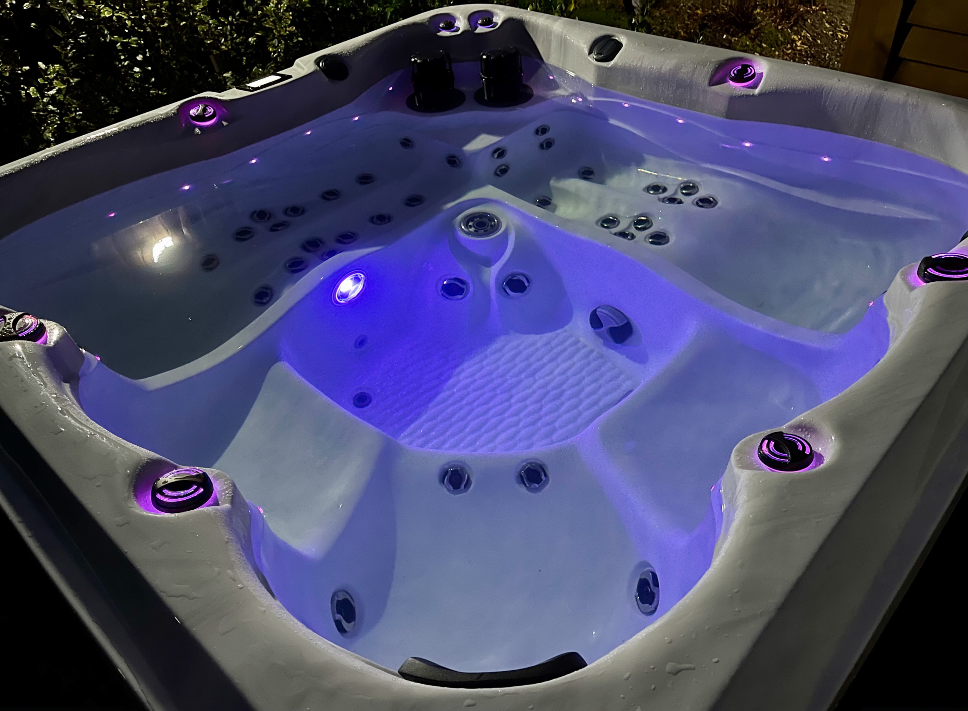 Spa rempli d'eau éclairé par des lumières bleutées