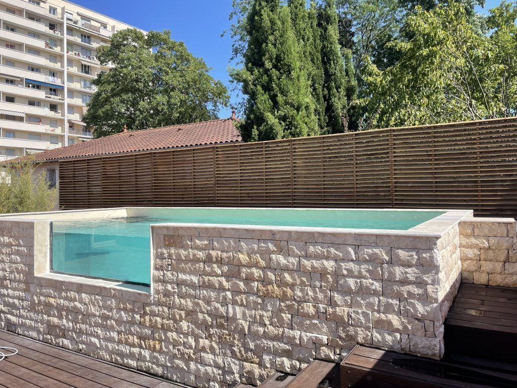 Piscine surélevée avec contour en pierre blanche
