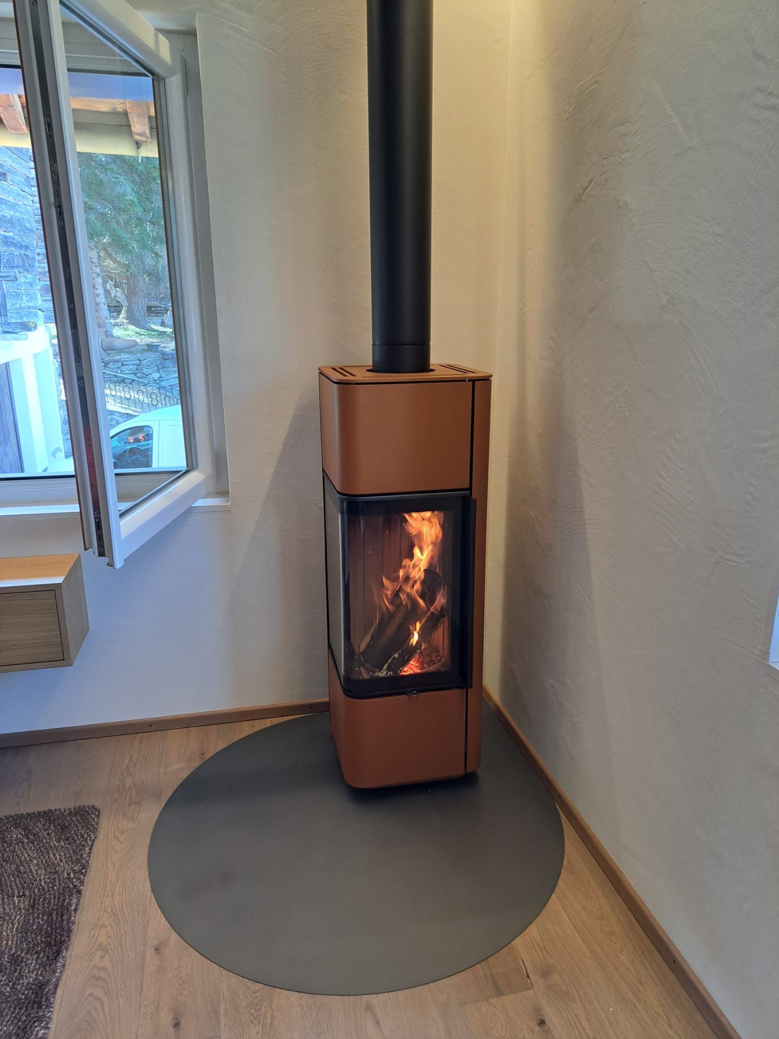 Un poêle à bois cuivré avec un feu allumé