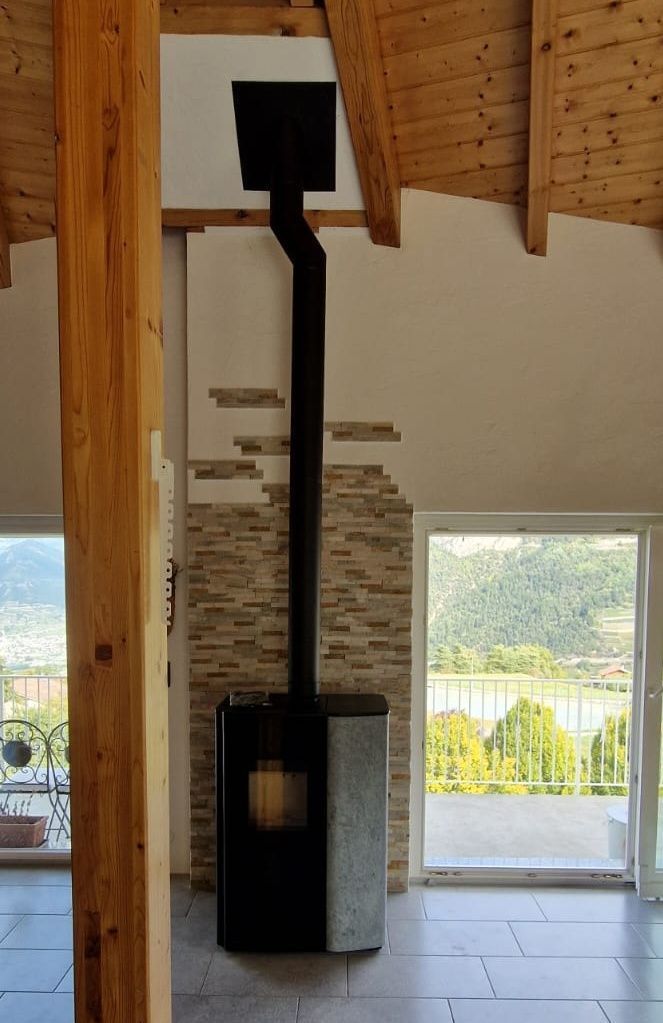 Une cheminée moderne avec une cheminée noire et un extérieur en pierre