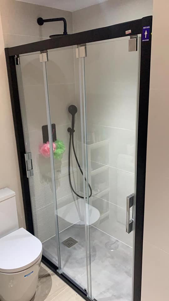 Un baño con inodoro, ducha y cabina de ducha.