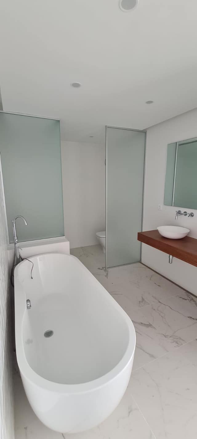 Un baño con bañera, lavabo, inodoro y espejo.