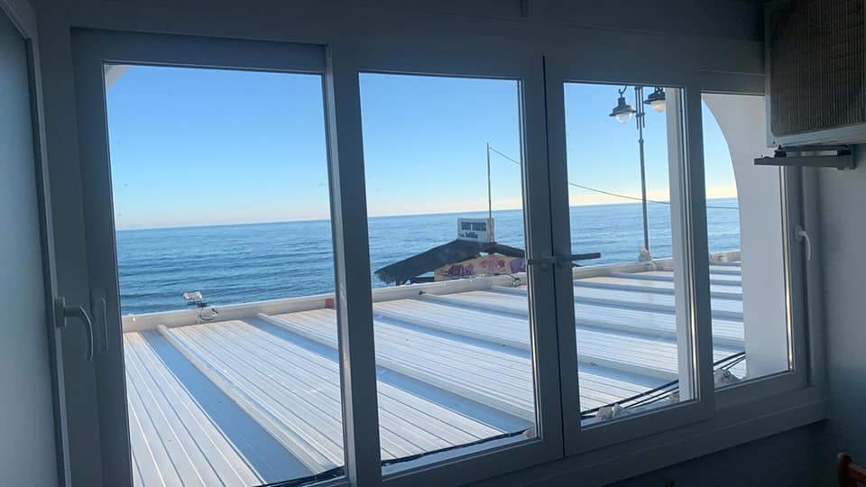 Una habitación con vista al mar a través de una ventana.