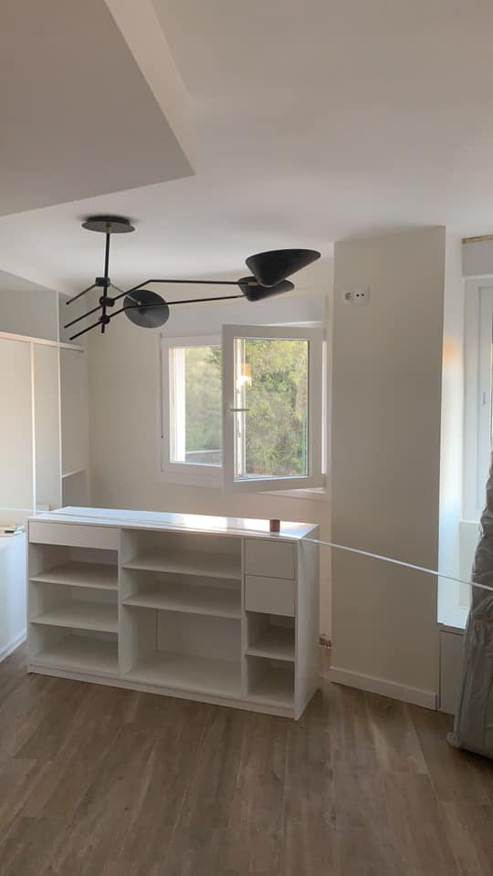 Una habitación vacía con un ventilador de techo y una ventana.