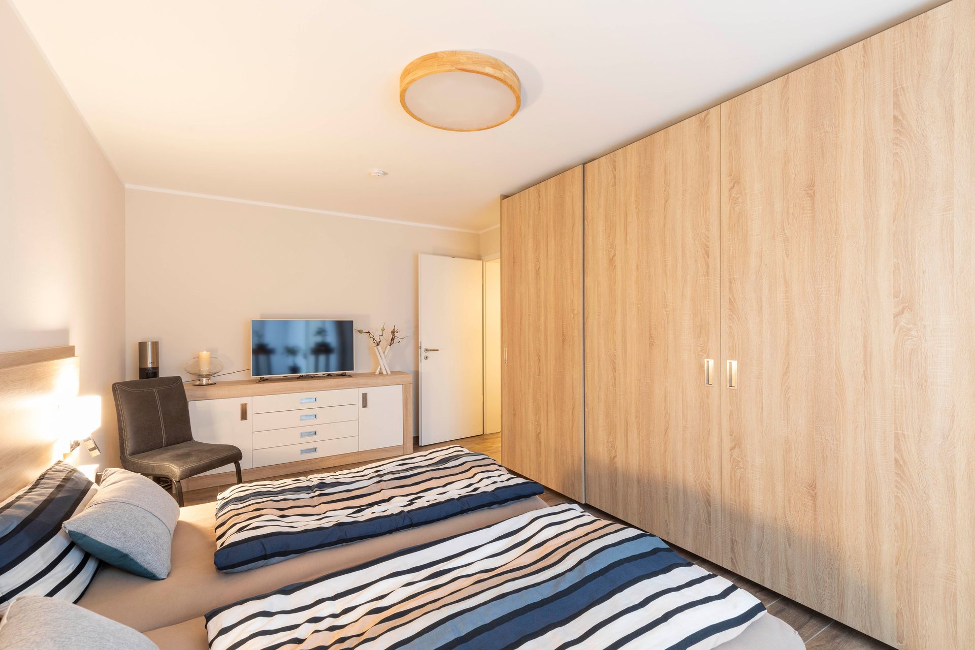 ein Schlafzimmer mit einem Bett , einem Stuhl und einem Fernseher