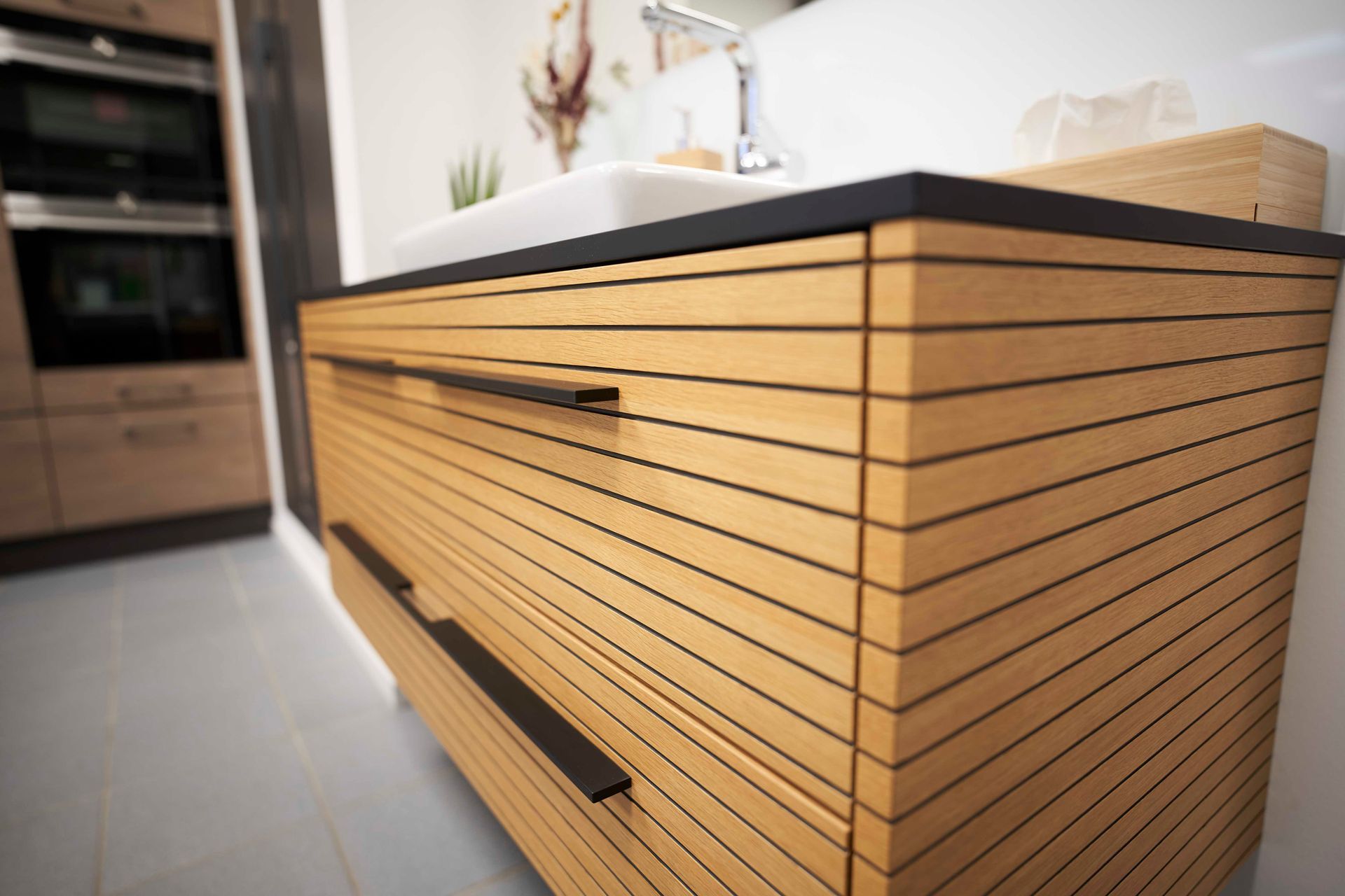 ein Holzschrank in einer Küche neben einem Waschbecken