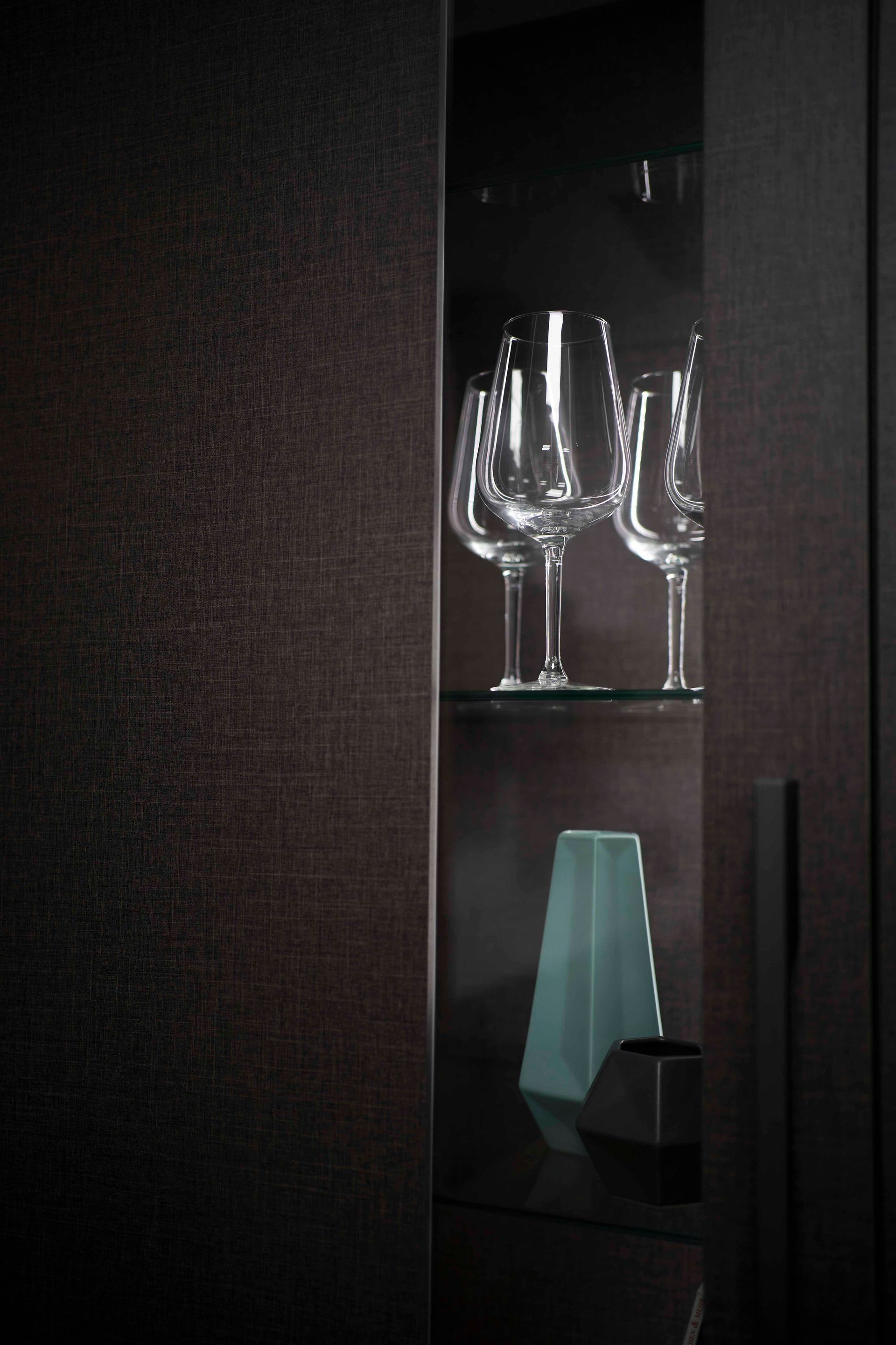 zwei Weingläser stehen auf einem Regal in einem dunklen Raum