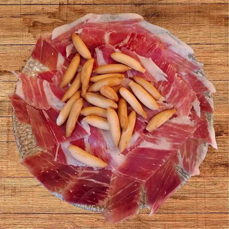 Dos sándwiches a la parrilla con jamón, queso y verduras sobre una tabla de madera, encima de un mantel a cuadros