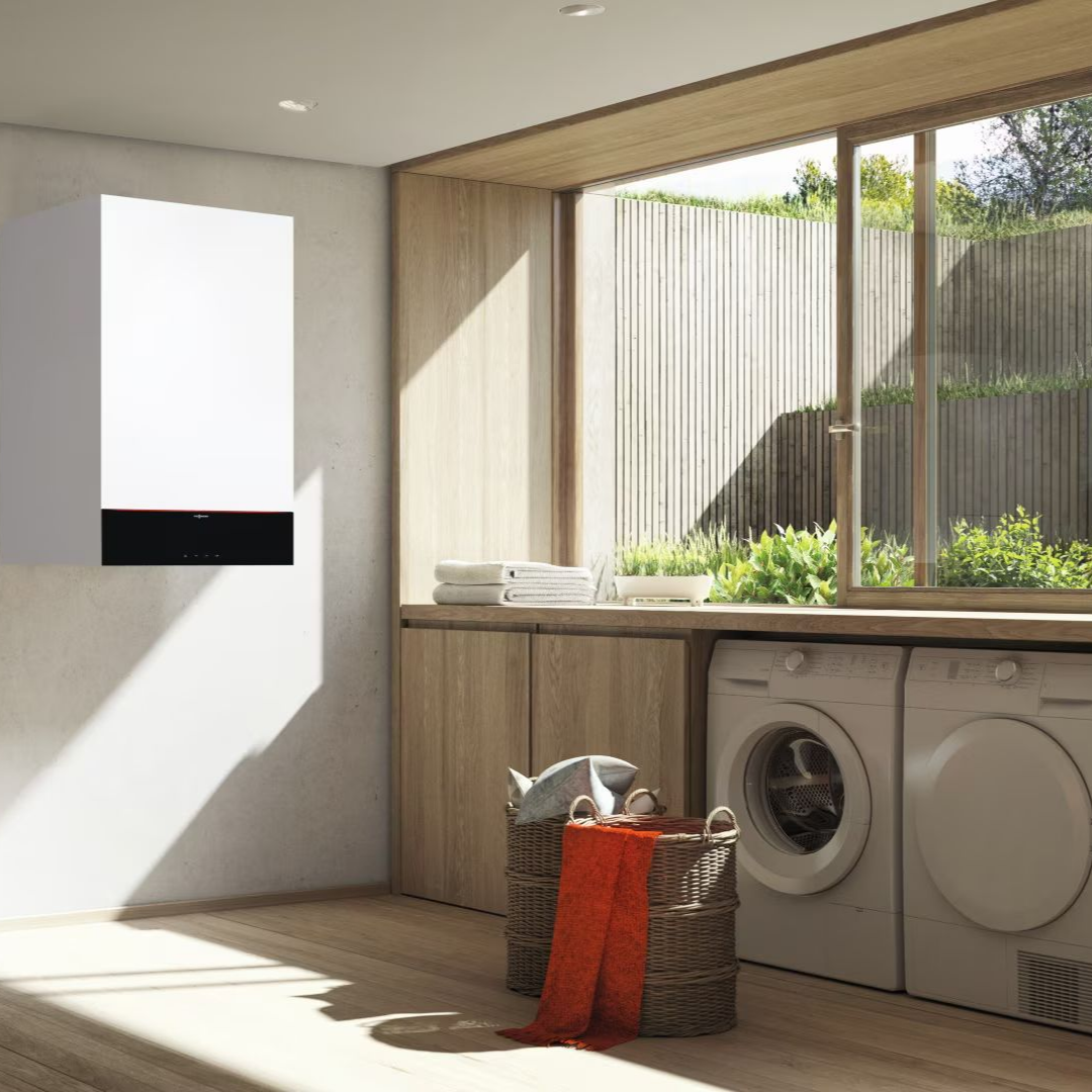 Chaudière à gaz murale blanche à l'intérieur d'un meuble en bois avec tuyauterie.