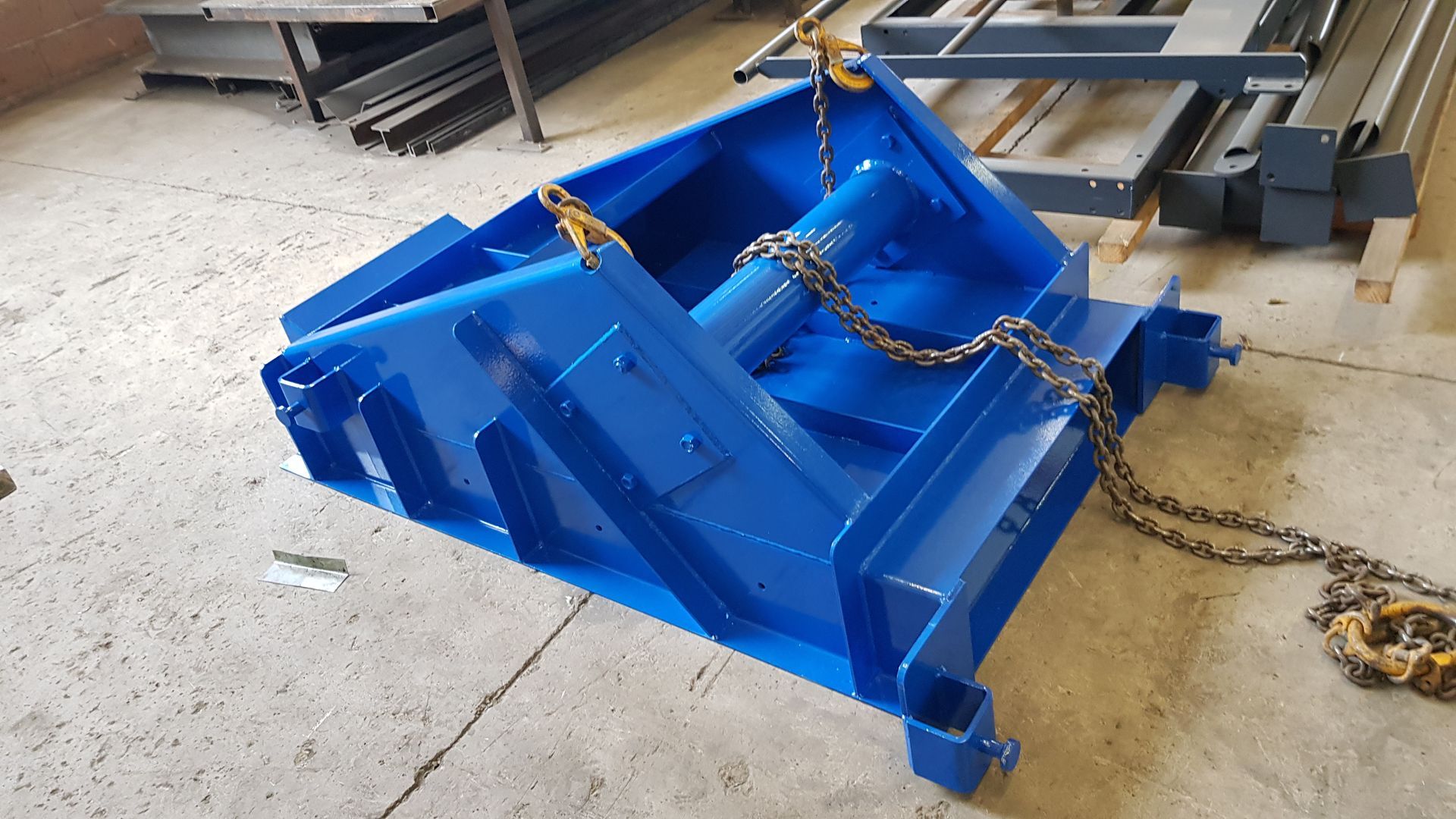 Pelle en métal pour engin de chantier dans un atelier