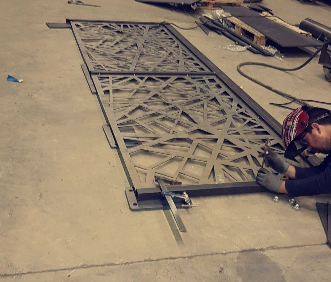 Portail en métal ouvragé au sol dans un atelier