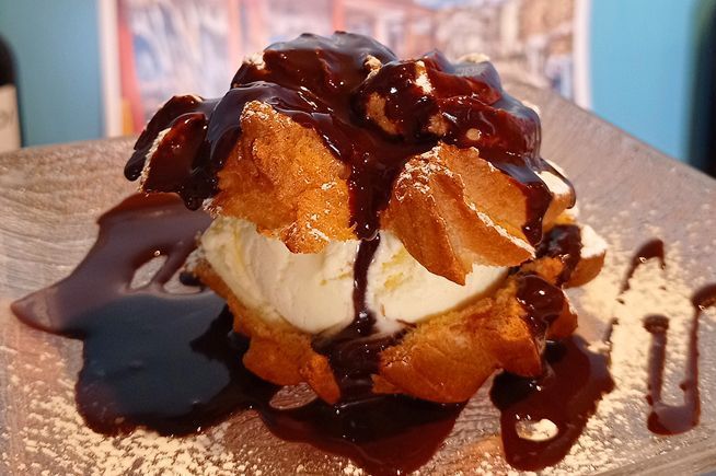Un postre con helado y salsa de chocolate en un plato.
