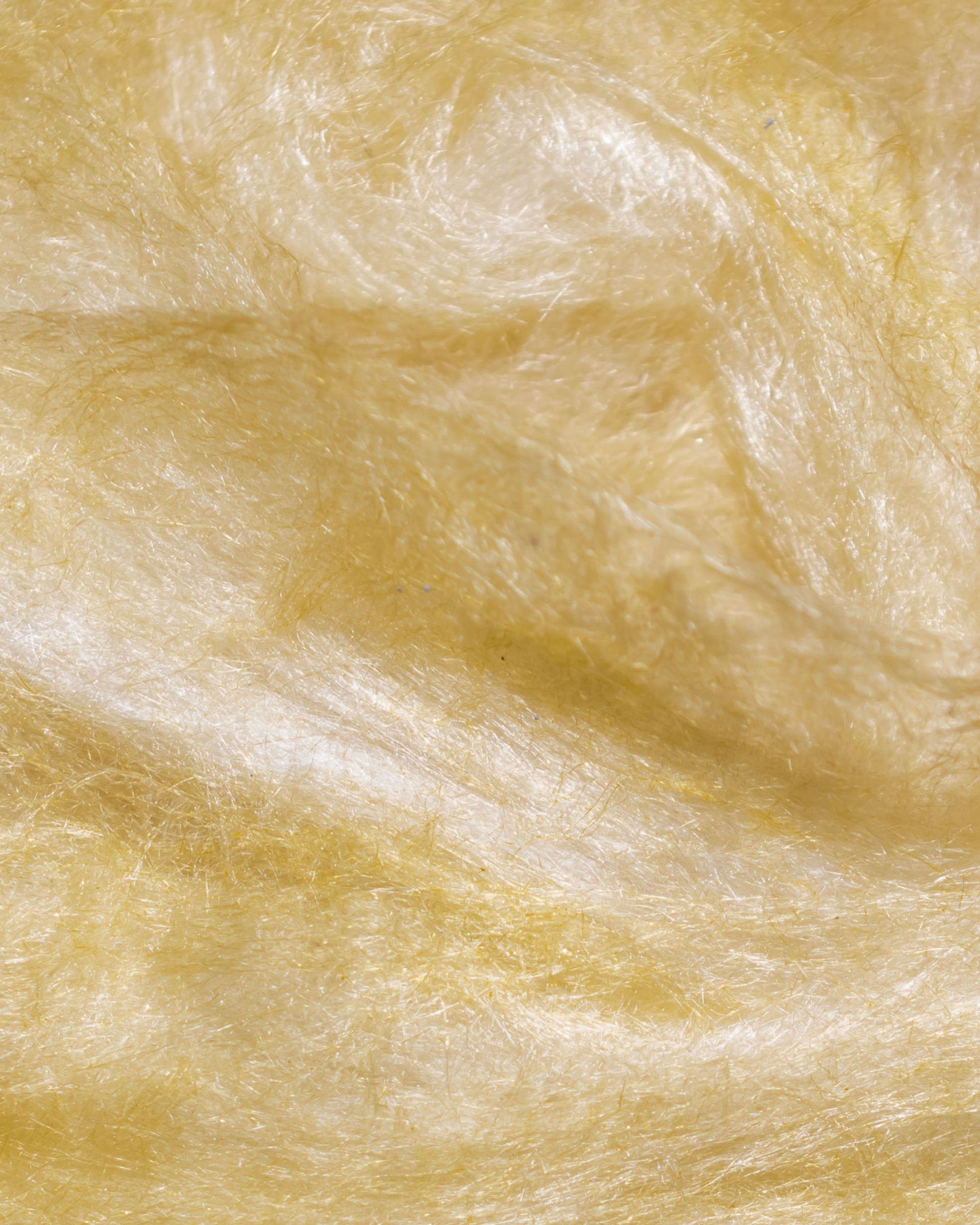 Matériau isolant jaune et duveteux à fibres ondulées.
