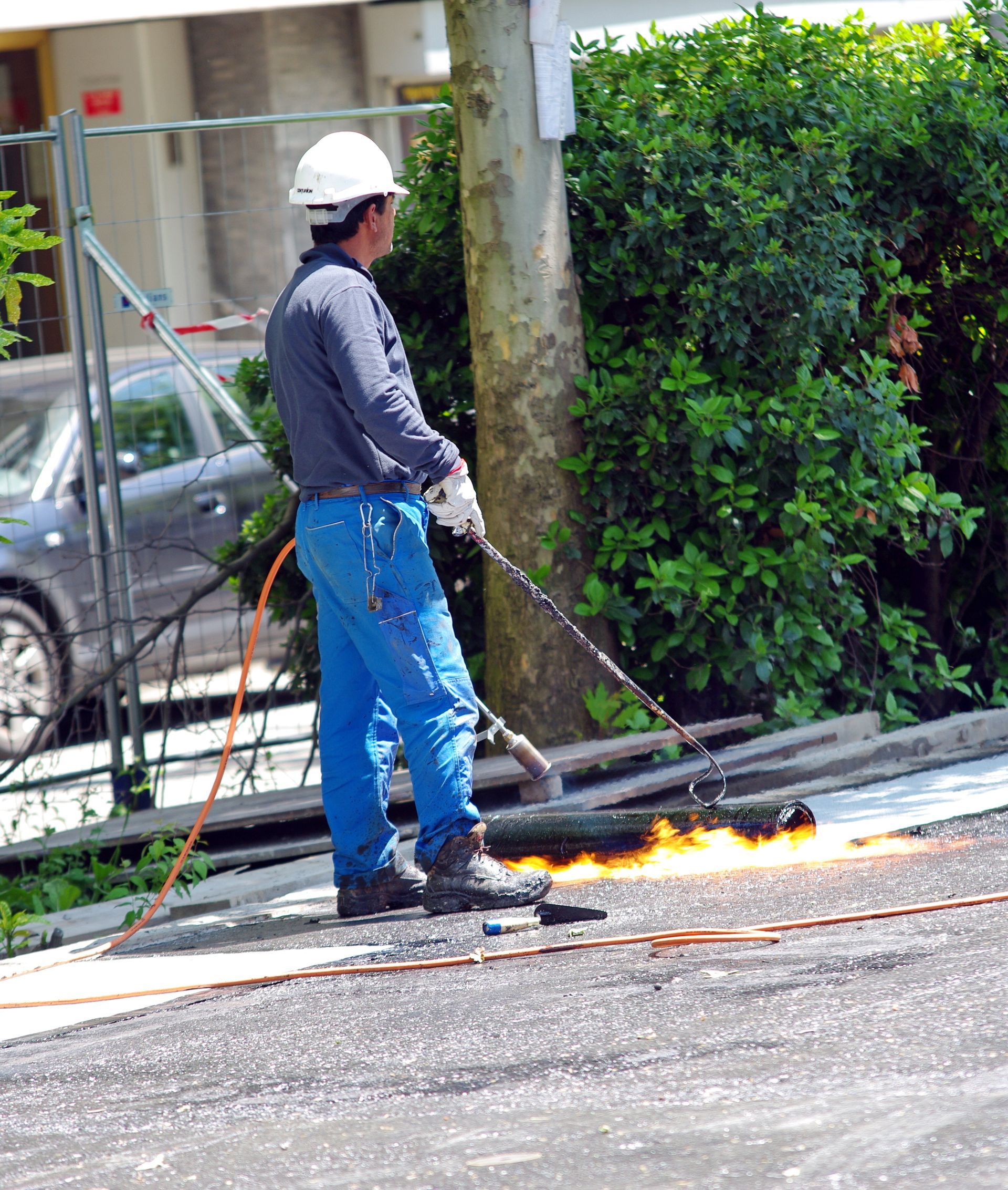 Personne installant des éléments d'étanchéité sur une charpente de toit.