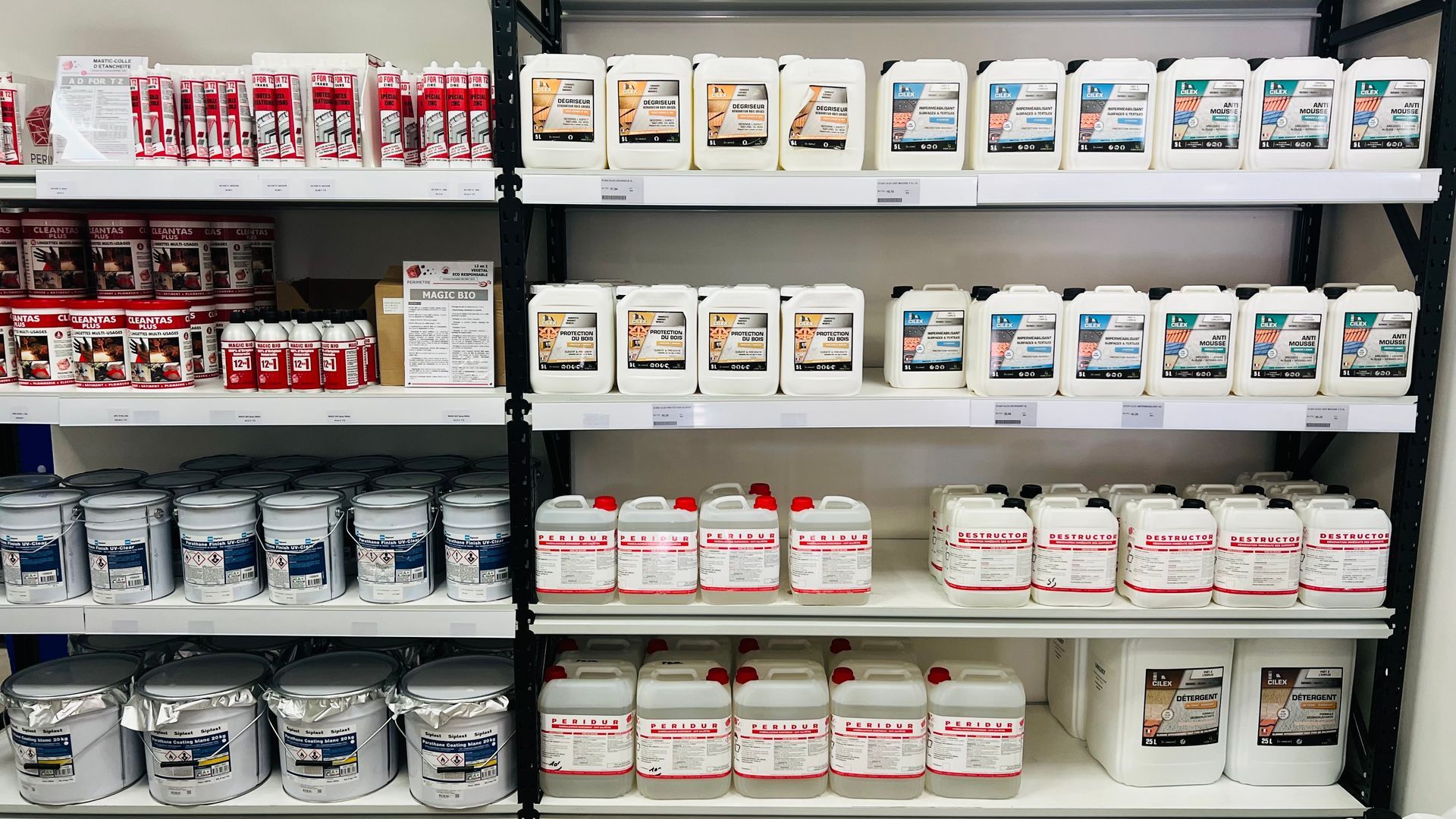 Des étagères remplies de divers contenants blancs et rouges dans un magasin.