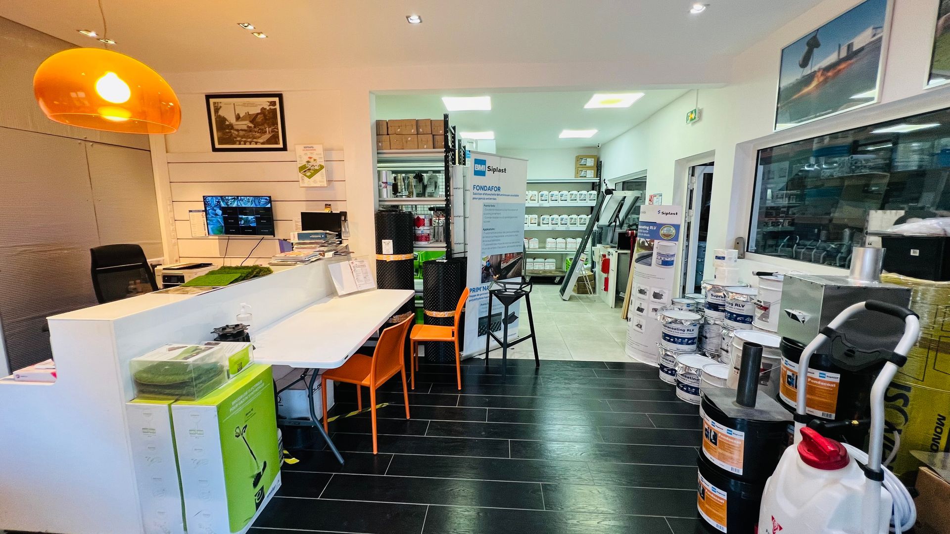 Des étagères remplies de divers contenants blancs et rouges de matériaux de construction dans un magasin.