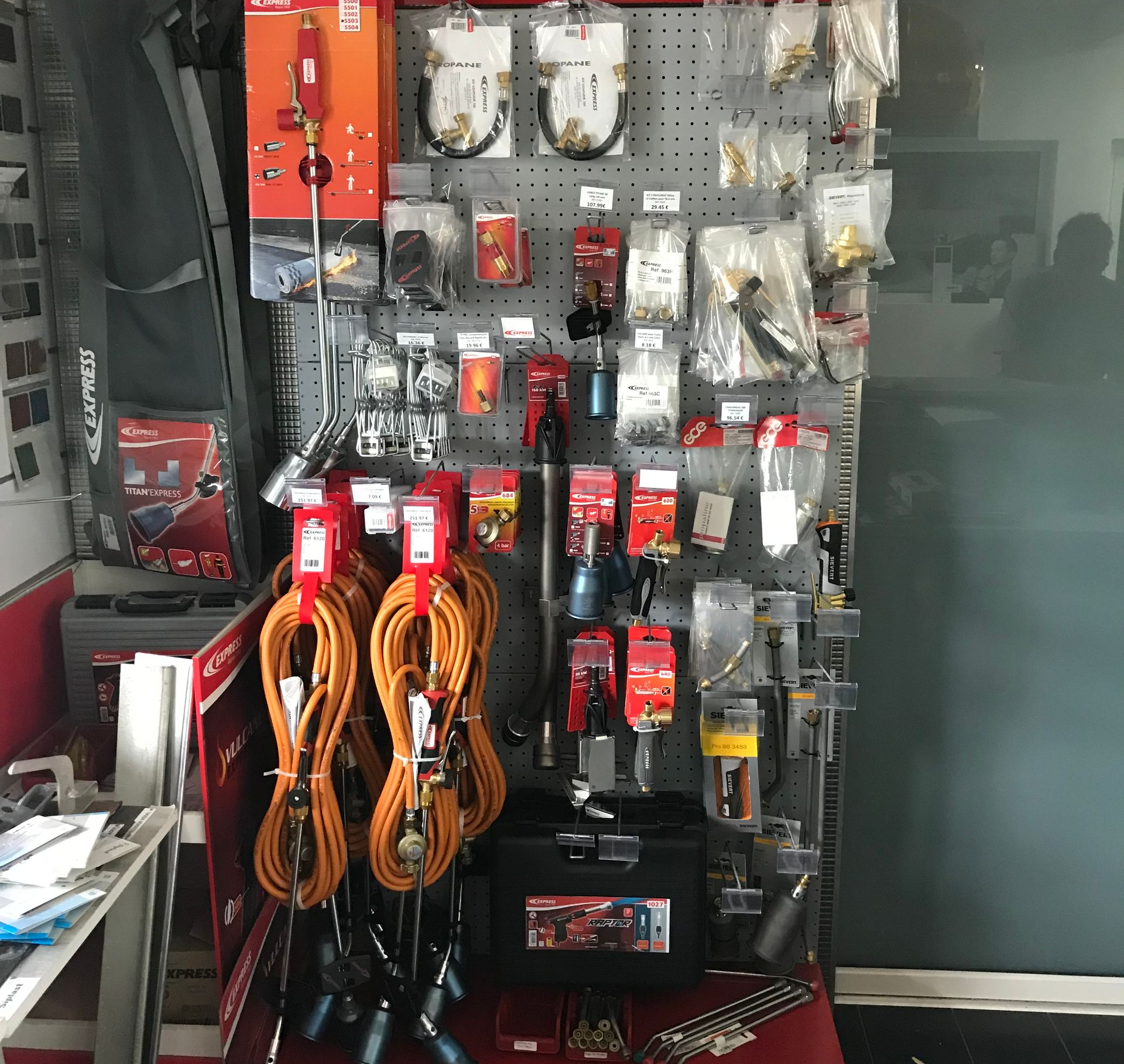 Présentoir de quincaillerie avec outillage, tuyaux et raccords.