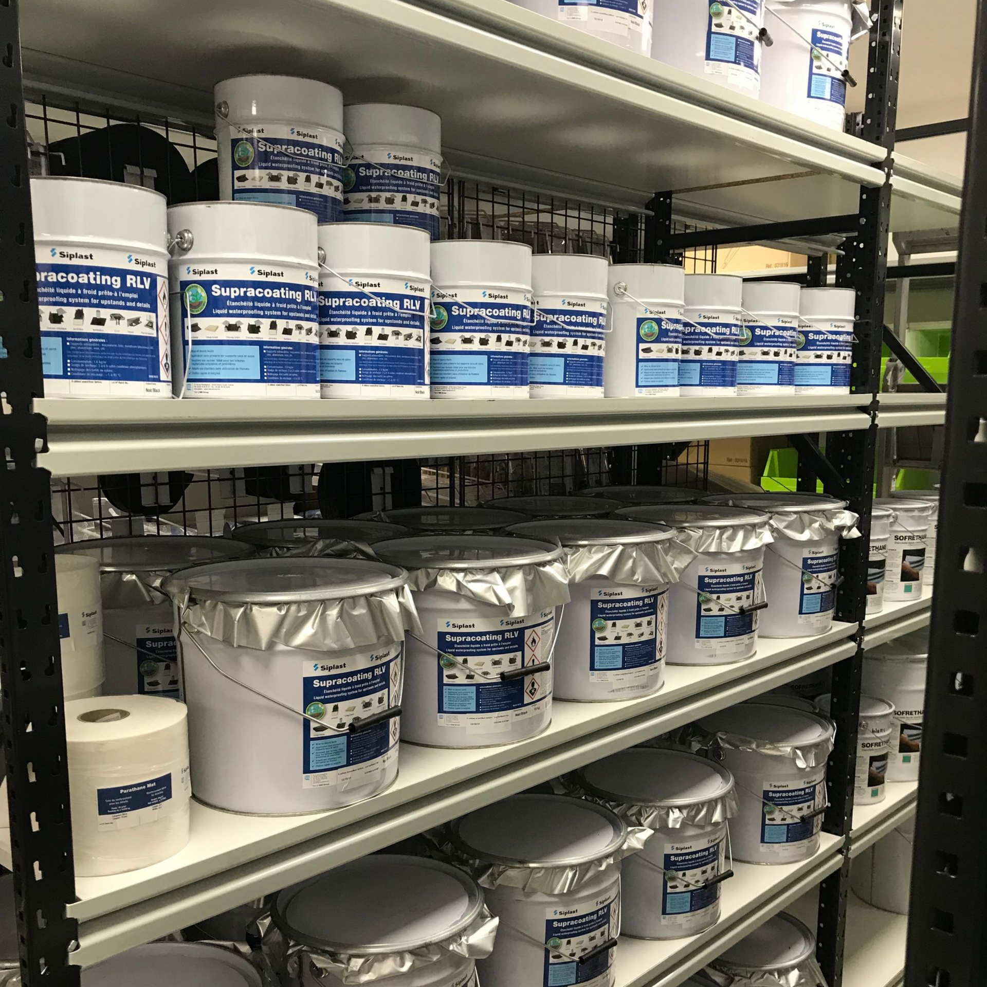 Des étagères remplies de seaux de produits d'étanchéité de différentes tailles