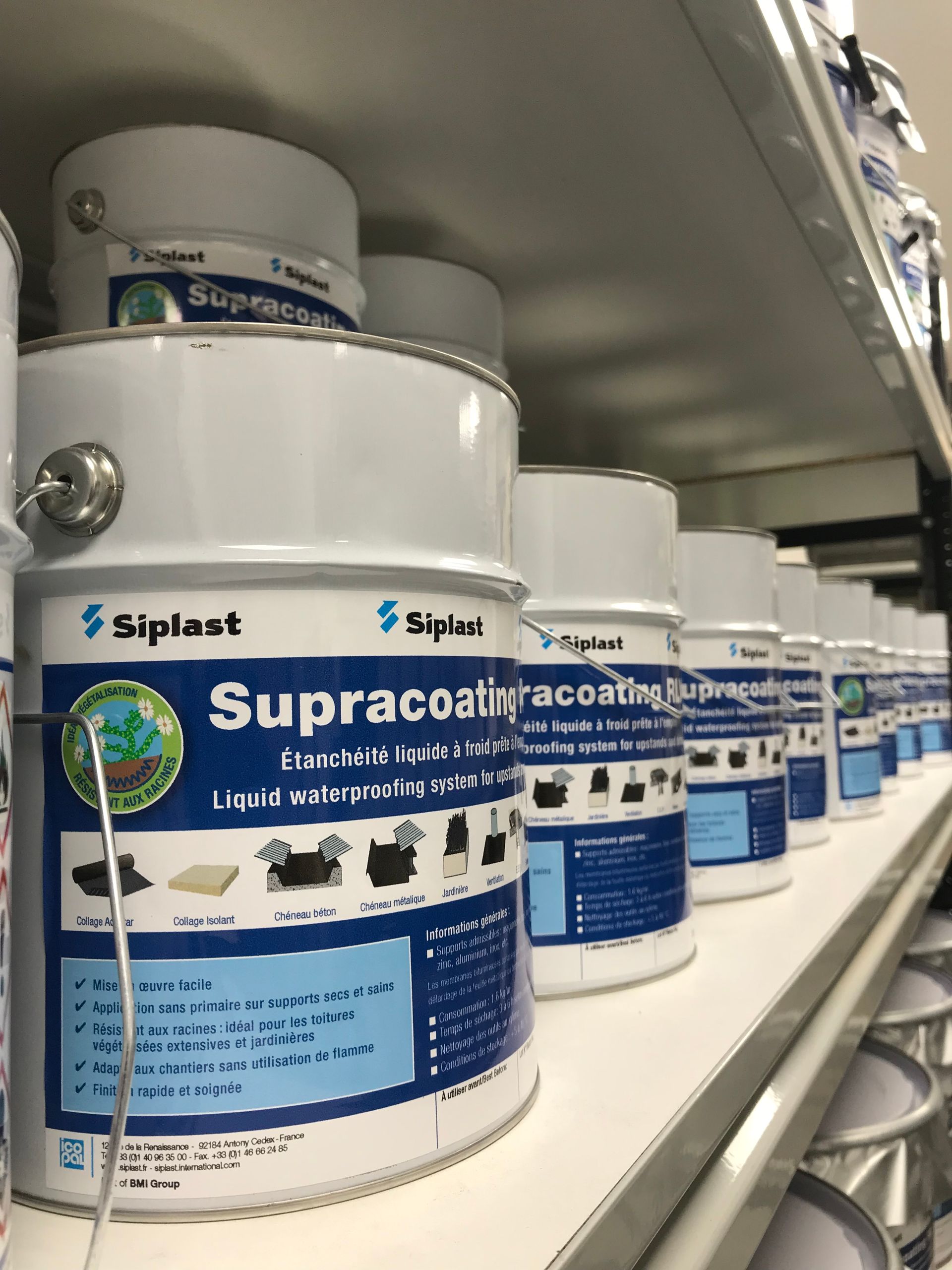 Des rangées de pots d'étanchéité étiquetés « Supracoting » sur une étagère de magasin.