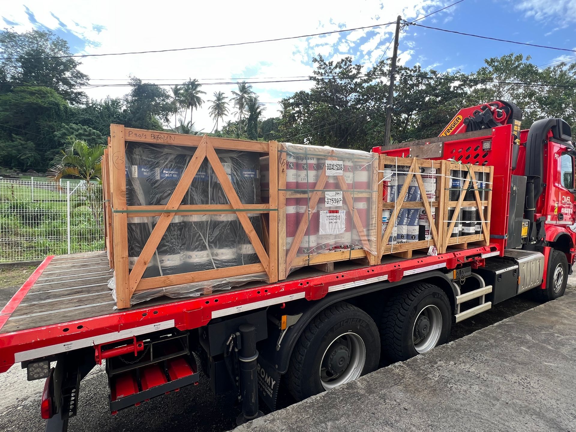 Des caisses de pots de produits d'étanchéité arrimées dans un conteneur à l'aide de supports et de sangles