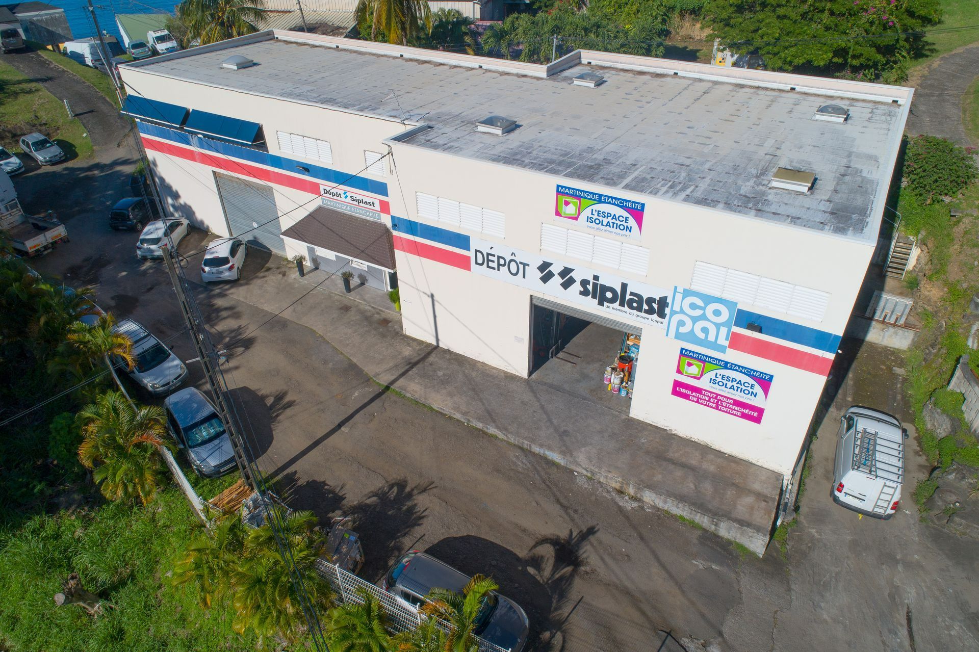 Bâtiment arborant l'enseigne « Siplast », ornée de rayures bleues, rouges et blanches.