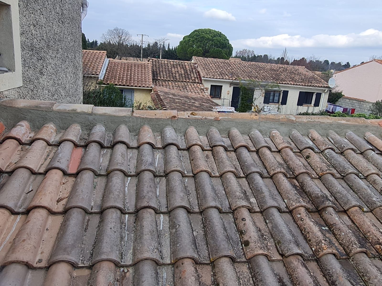 Gros plan sur des tuiles de terre cuite usées par le temps.