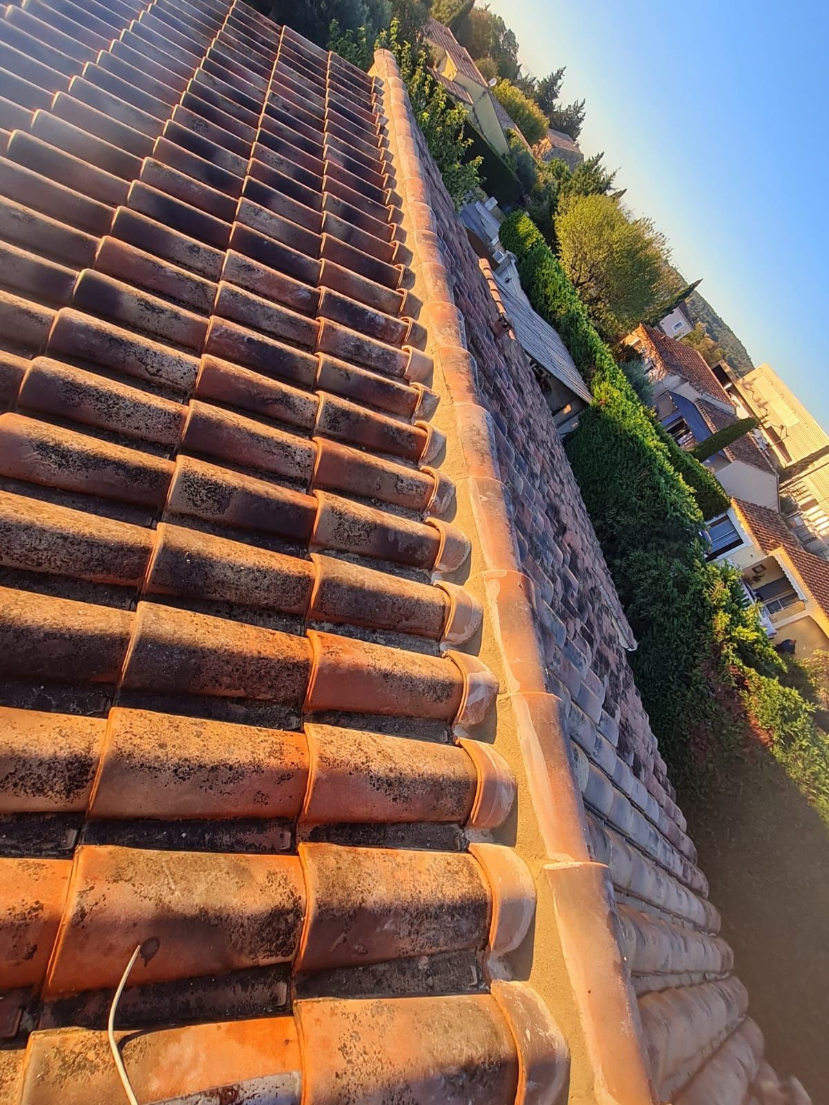 Vue en plongée d'un toit de tuiles en pente.