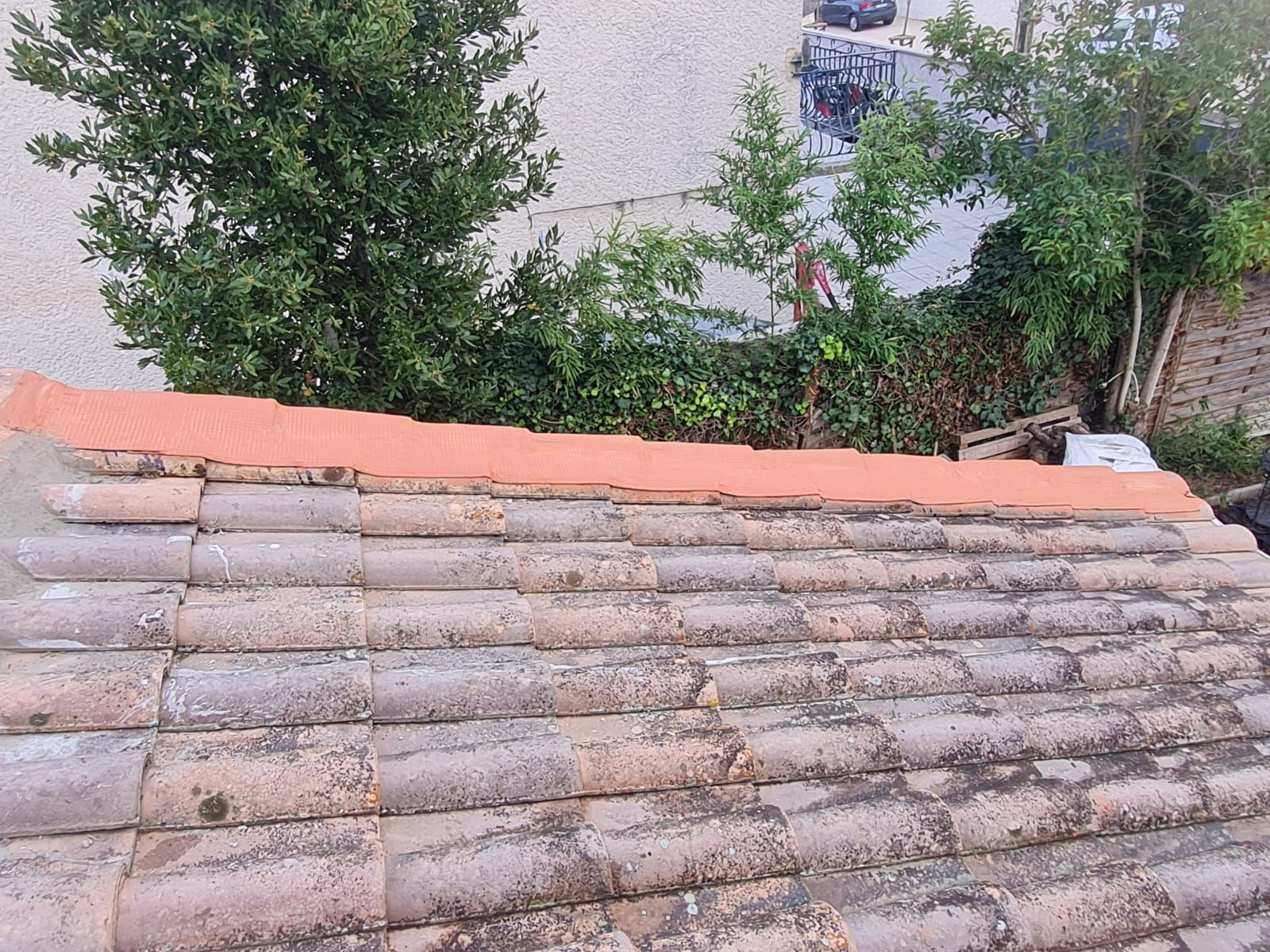 Gros plan sur un vieux toit de tuiles avec une seule rangée de tuiles de remplacement neuves.