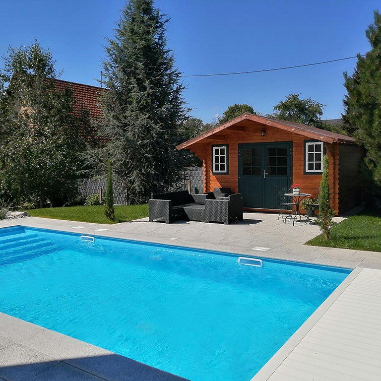 Une piscine devant une cabane en bois