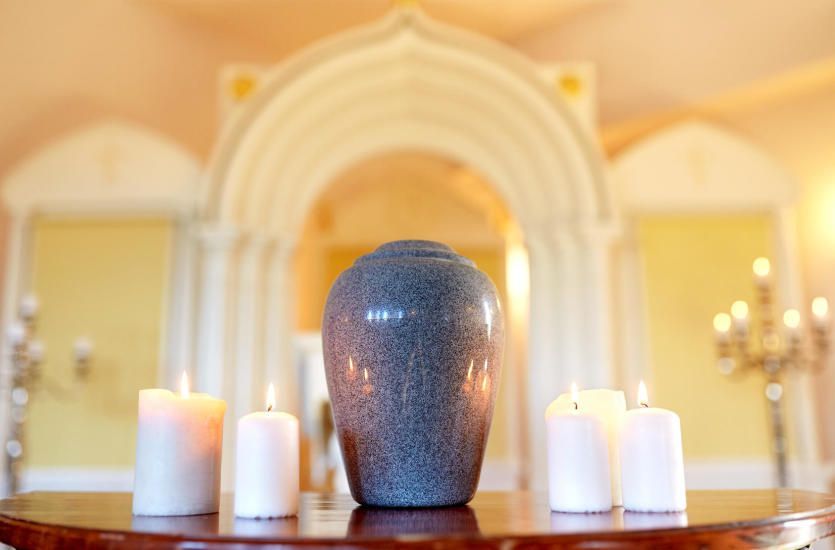 Un jarrón está sobre una mesa al lado de velas en una habitación.