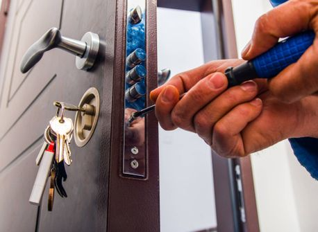 Una persona está arreglando una puerta con un destornillador.