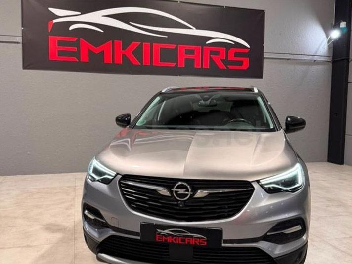 SUV Opel plateado expuesto en el interior de la sala de exposición del concesionario EMKICARS.