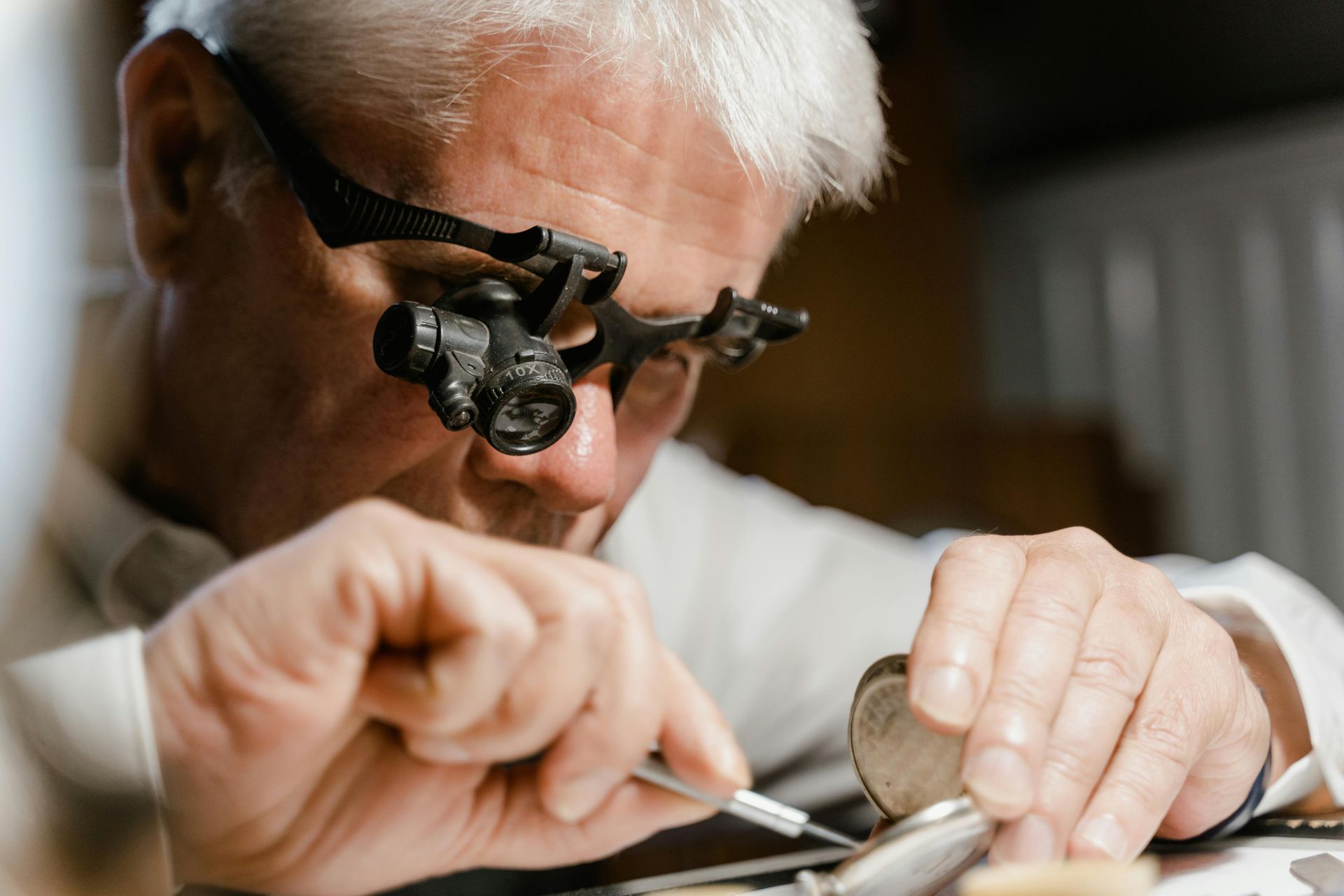 Analyse d'une montre par un horloger en gros plan.