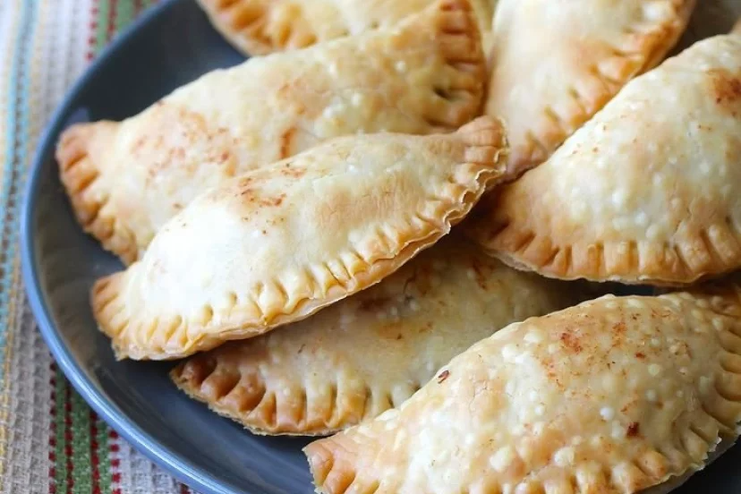 Un primer plano de un plato de empanadas en una mesa.