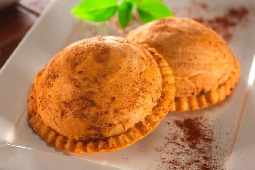 Dos pasteles con canela están en un plato blanco.