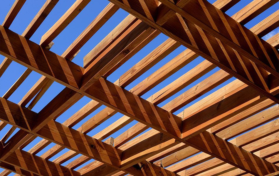 Lames de bois d'une pergola sous un ciel bleu