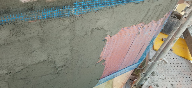 Un primer plano de una pared que se está enyesando en un sitio de construcción.