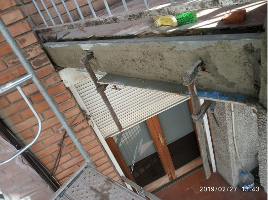 Un edificio de ladrillo con una ventana y un andamio delante.