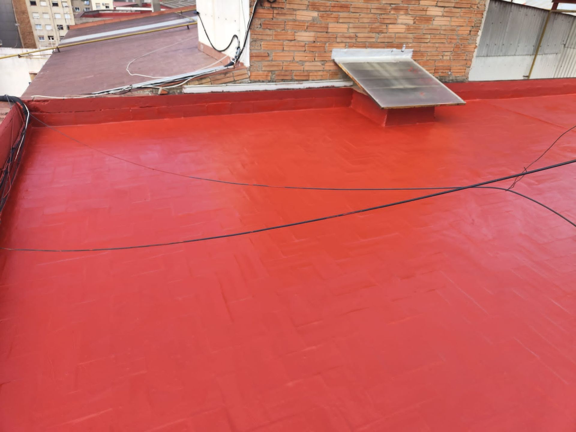 Un techo rojo con una pared de ladrillos al fondo.