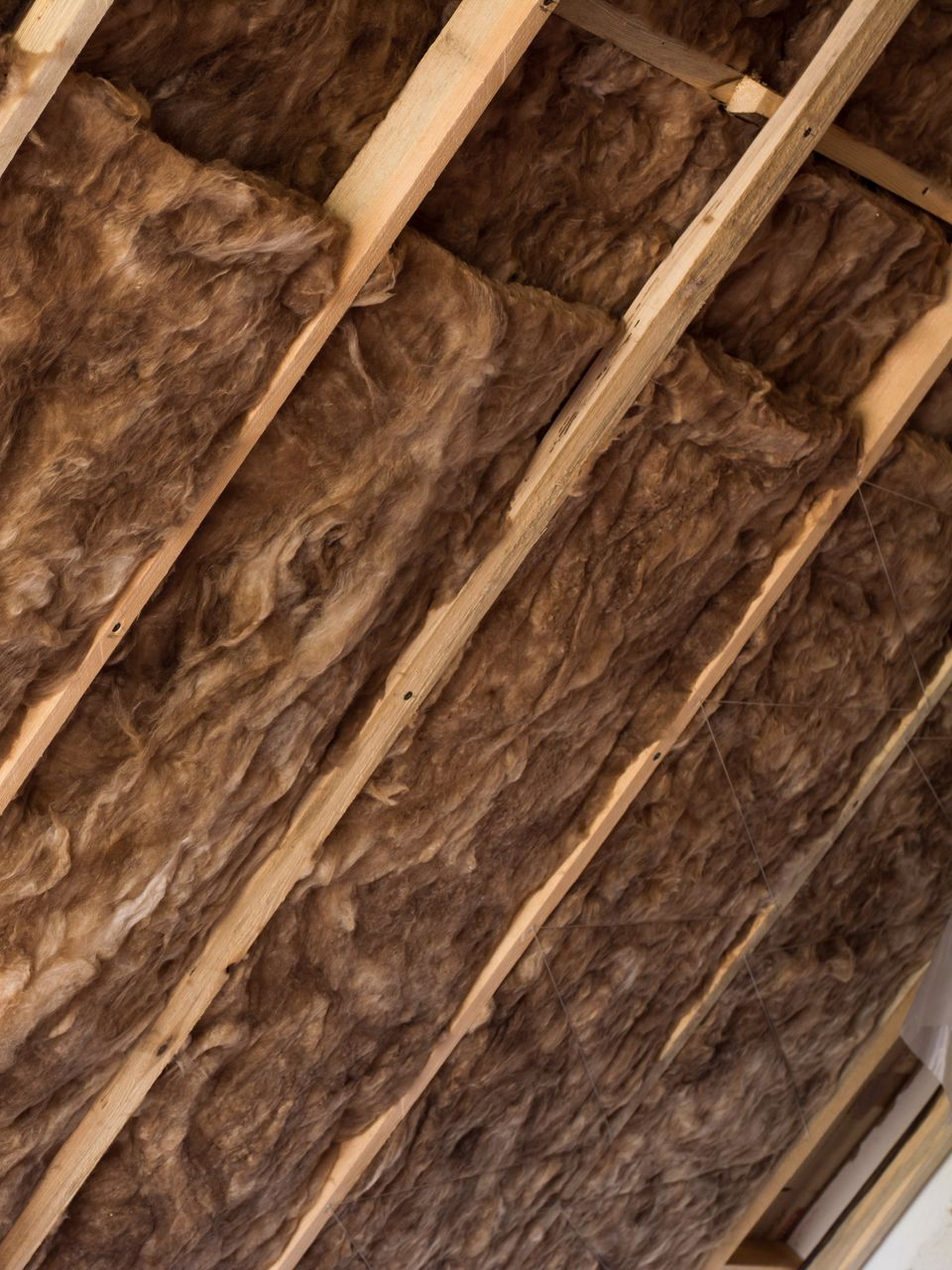 Chevrons en bois avec isolation brune entre eux.