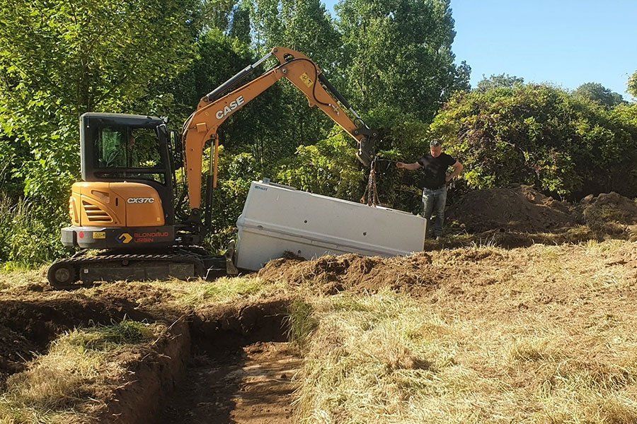 Petite pelleteuse en train de porter un bloc