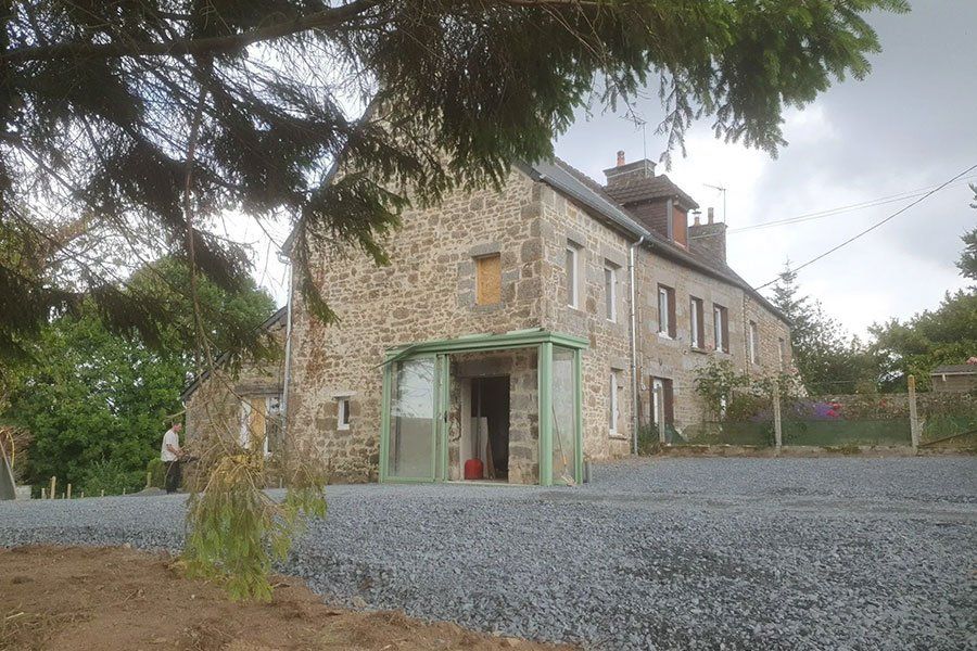 Maison en pierre blanche avec des graviers devant