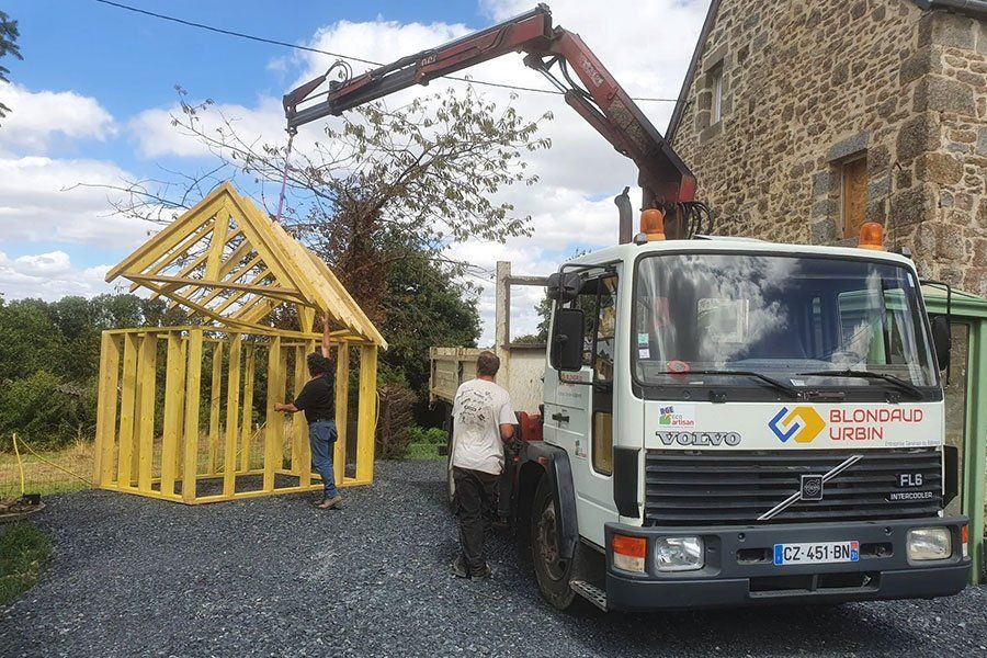 Un camion qui porte la charpente en bois d'une maison