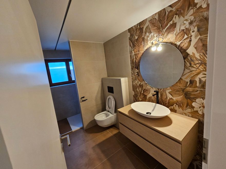 vue d'une salle de bain avec une vasque, un toilette et un miroir rond