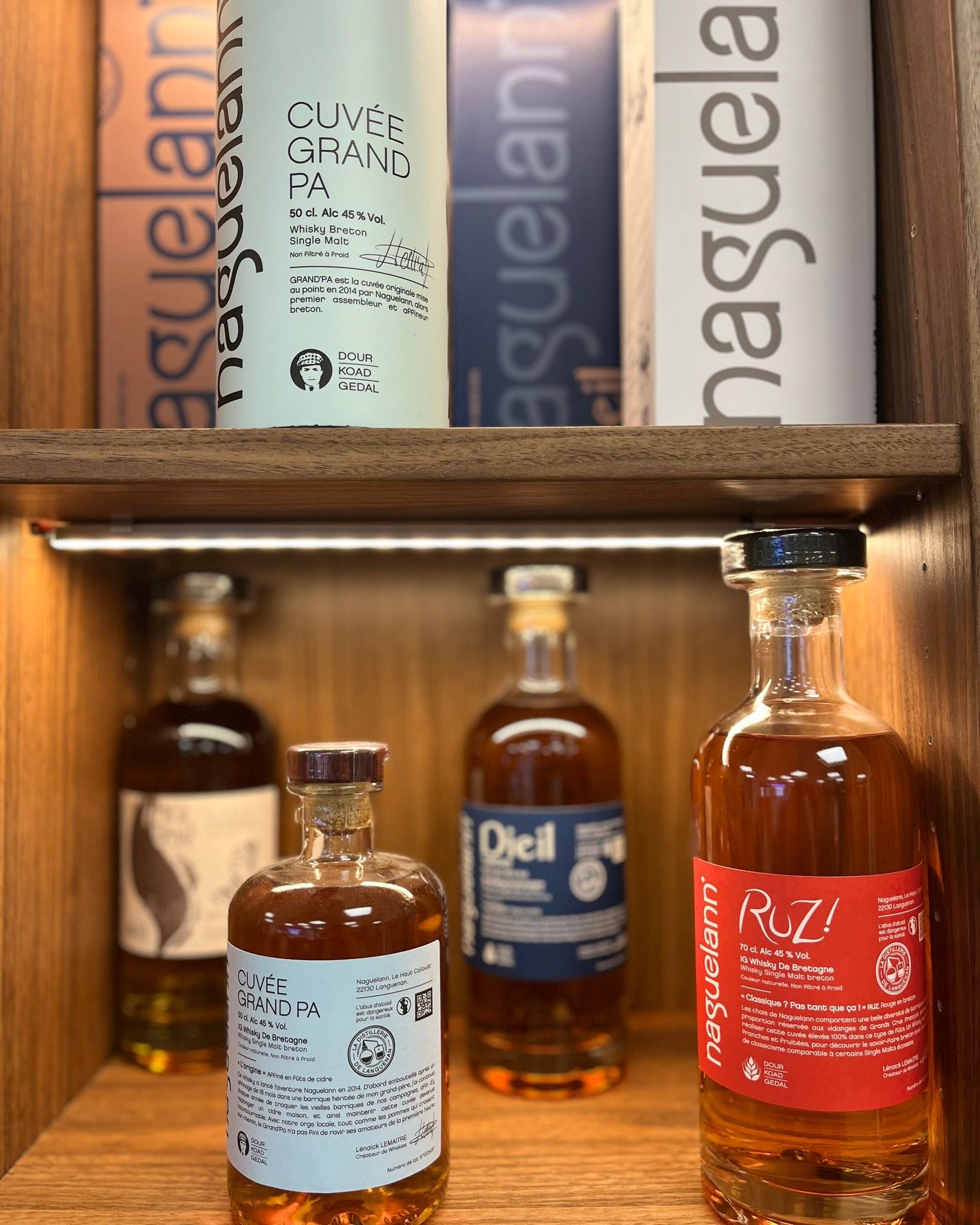 Étagère en bois avec plusieurs bouteilles de whisky et des spiritueux.