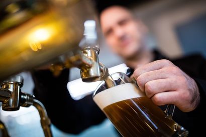 Un barman remplit un verre de bière ambrée à la pression.