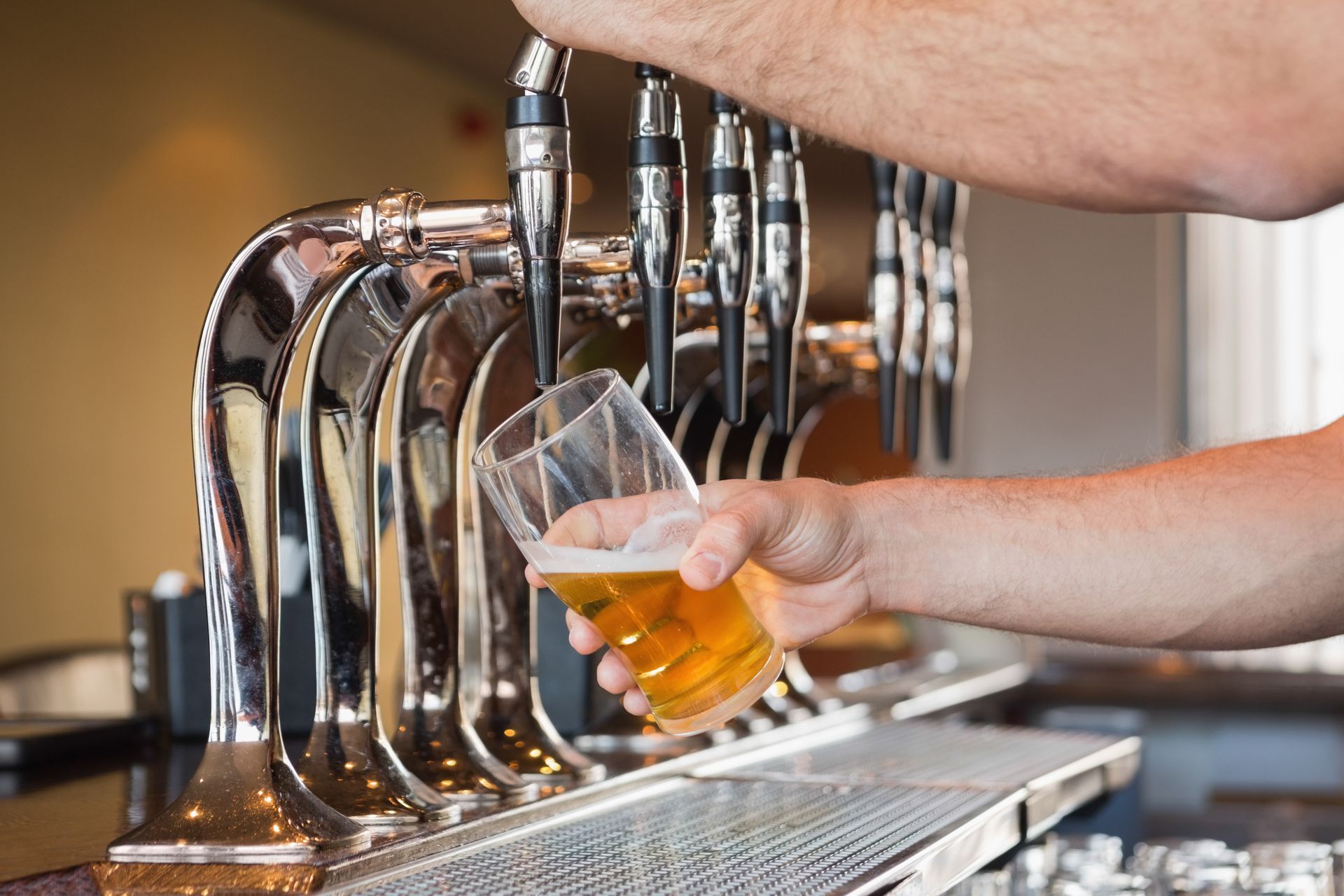 Servir de la bière à la main d'un robinet dans un gobelet en plastique transparent au bar